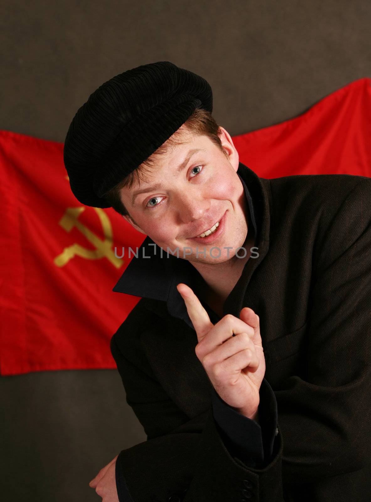 Portrait of the man in a cap on a background of a red flag