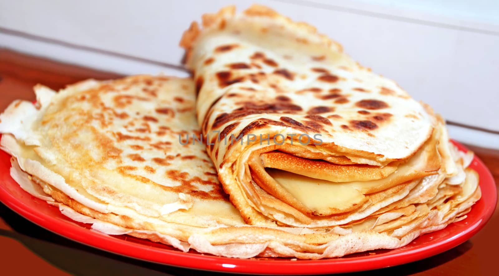 appetizing pancakes on red plate