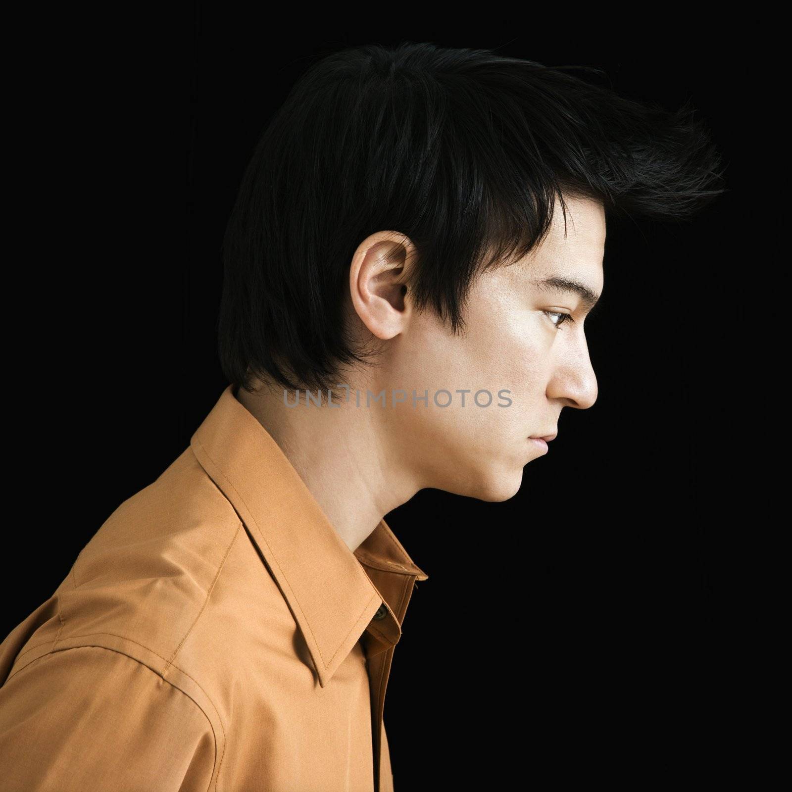 Side profile of serious Asian young man.