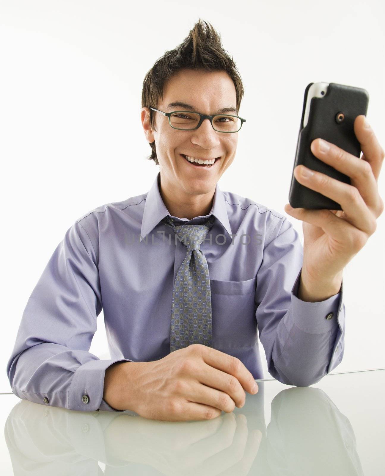 Smiling businessman with cell phone. by iofoto