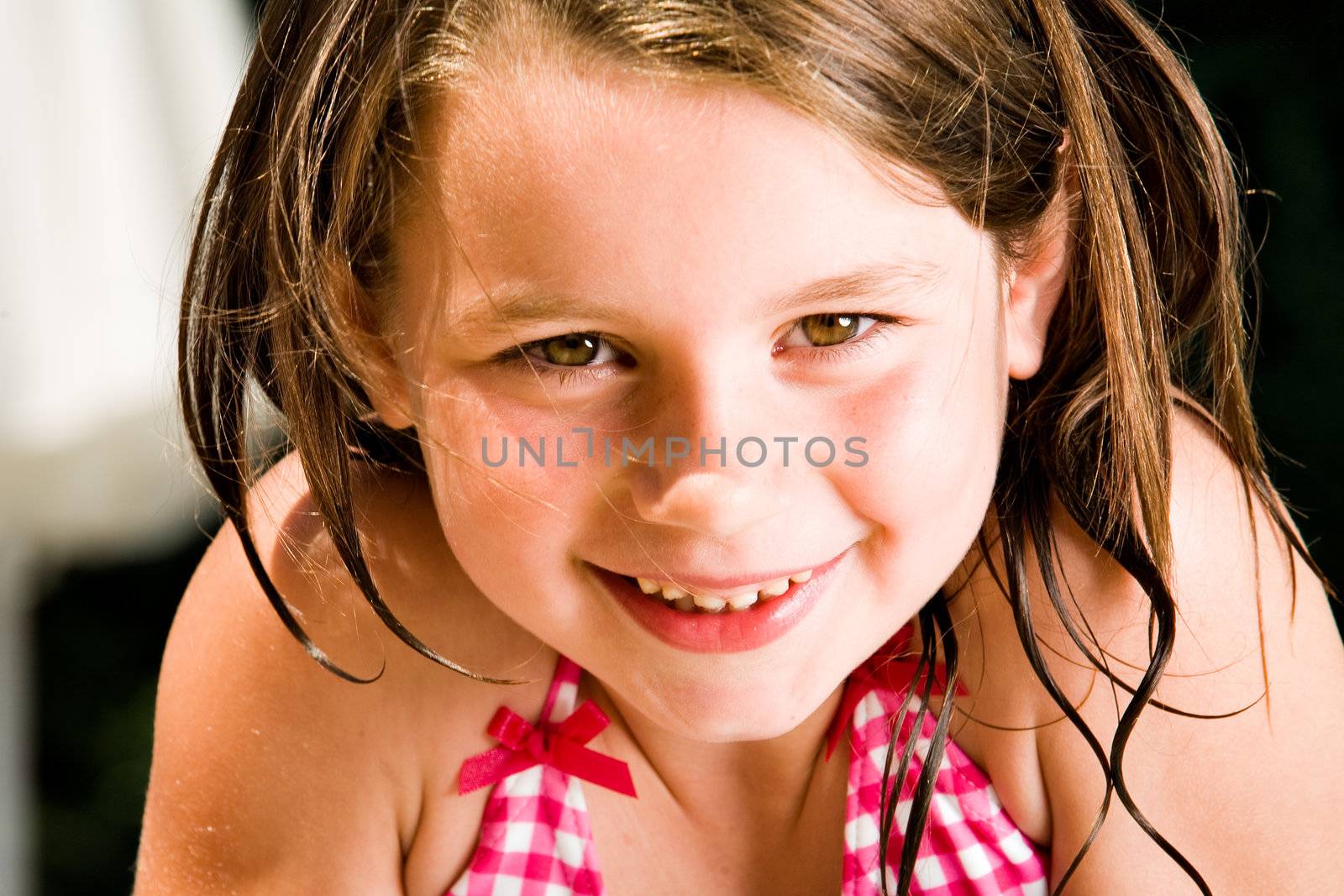 Young child enjoying the sun in and around the swimming pool