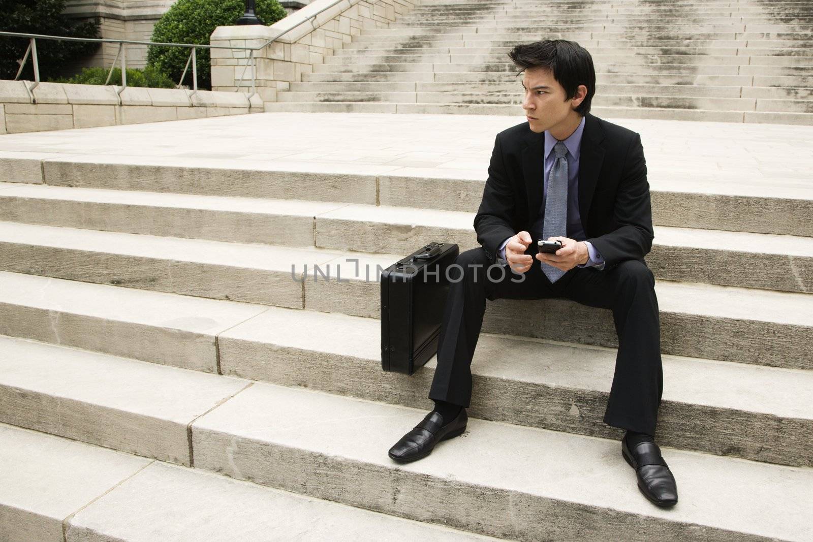 Businessman sitting on steps. by iofoto