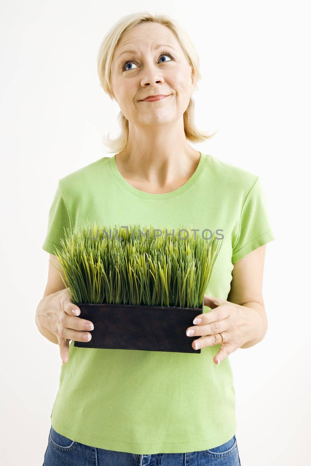 Woman holding potted grass. by iofoto