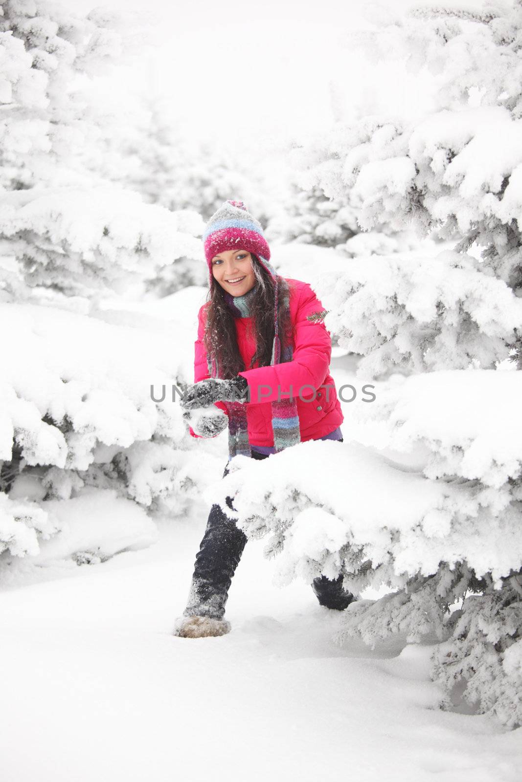 winter woman play snowballs on snow background