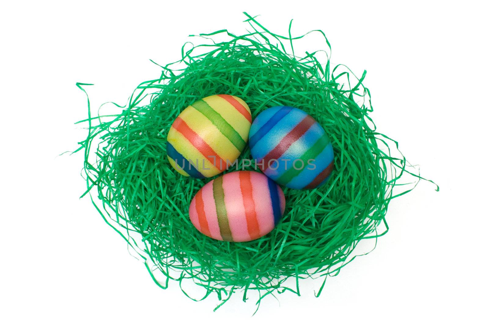 Colored eggs on artificial grass. Isolated on a white background.