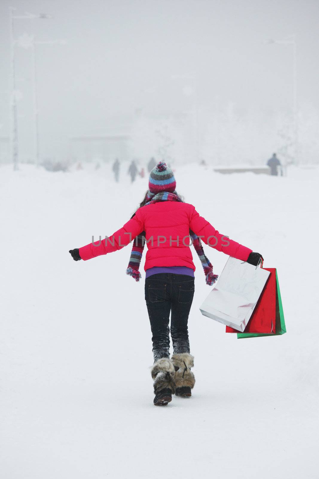 winter girl with gift bags on snow background