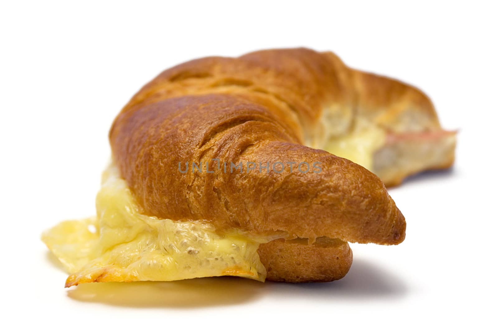 Croissant with ham and cheese isolated on a white background.