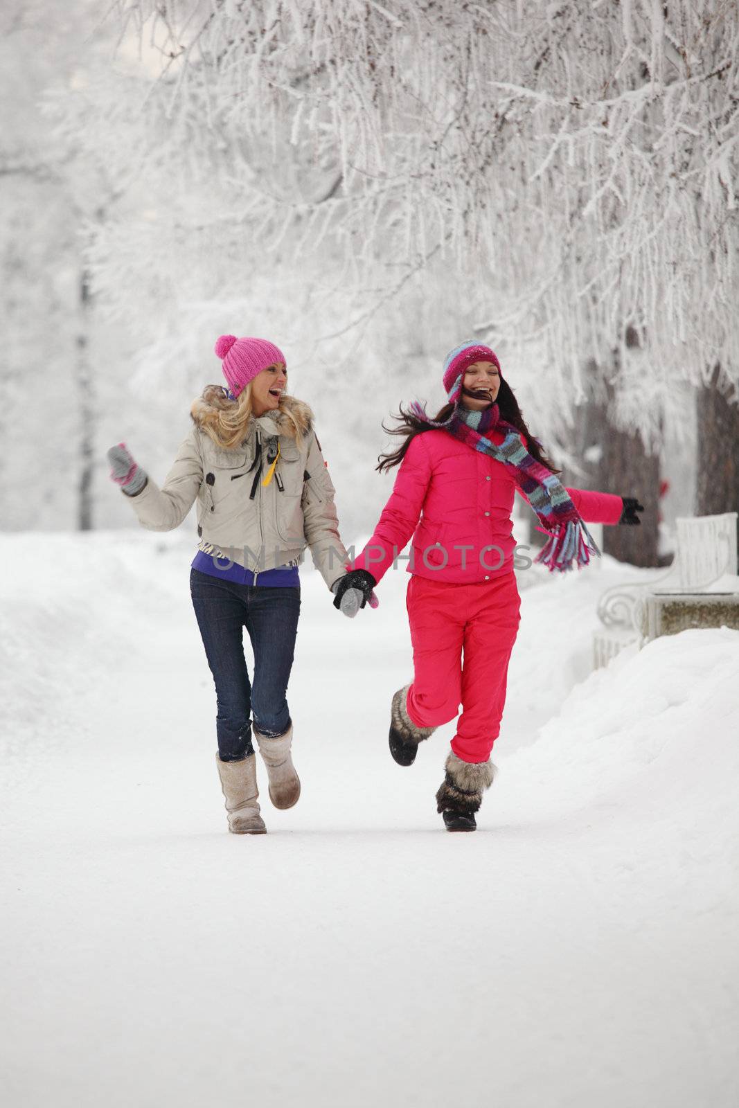 two winter women run by snow frosted alley