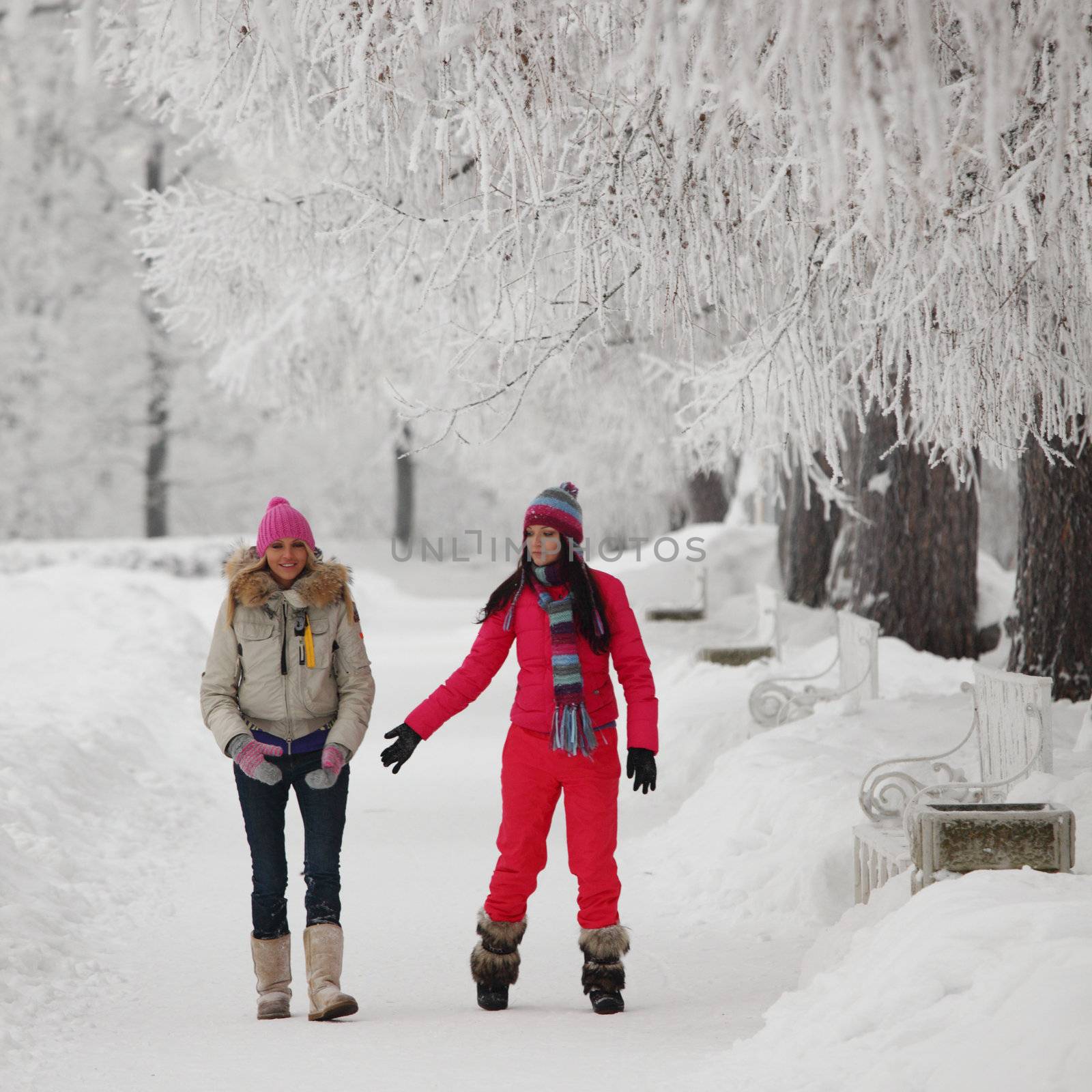 two winter women run by snow frosted alley