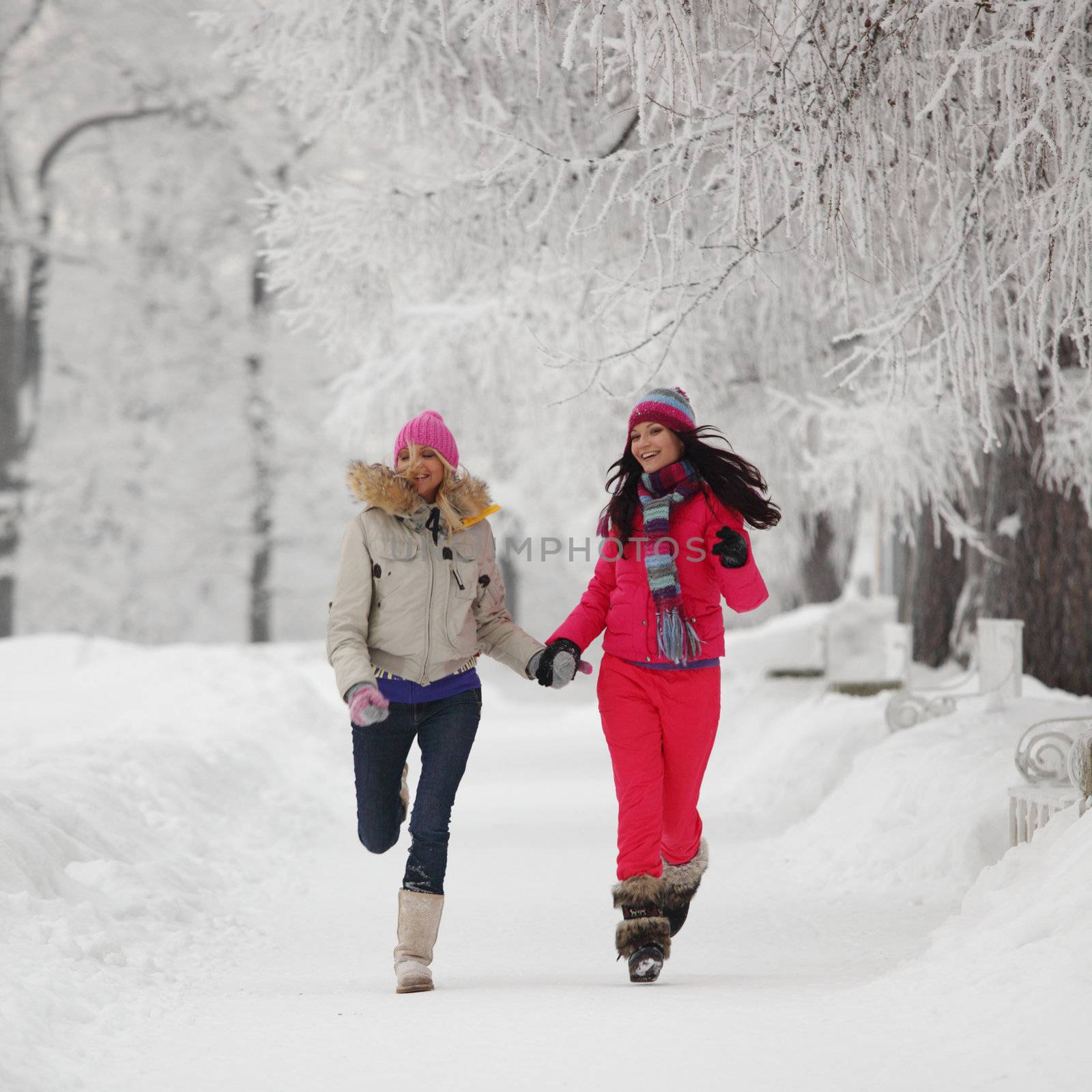 two winter women run by snow frosted alley