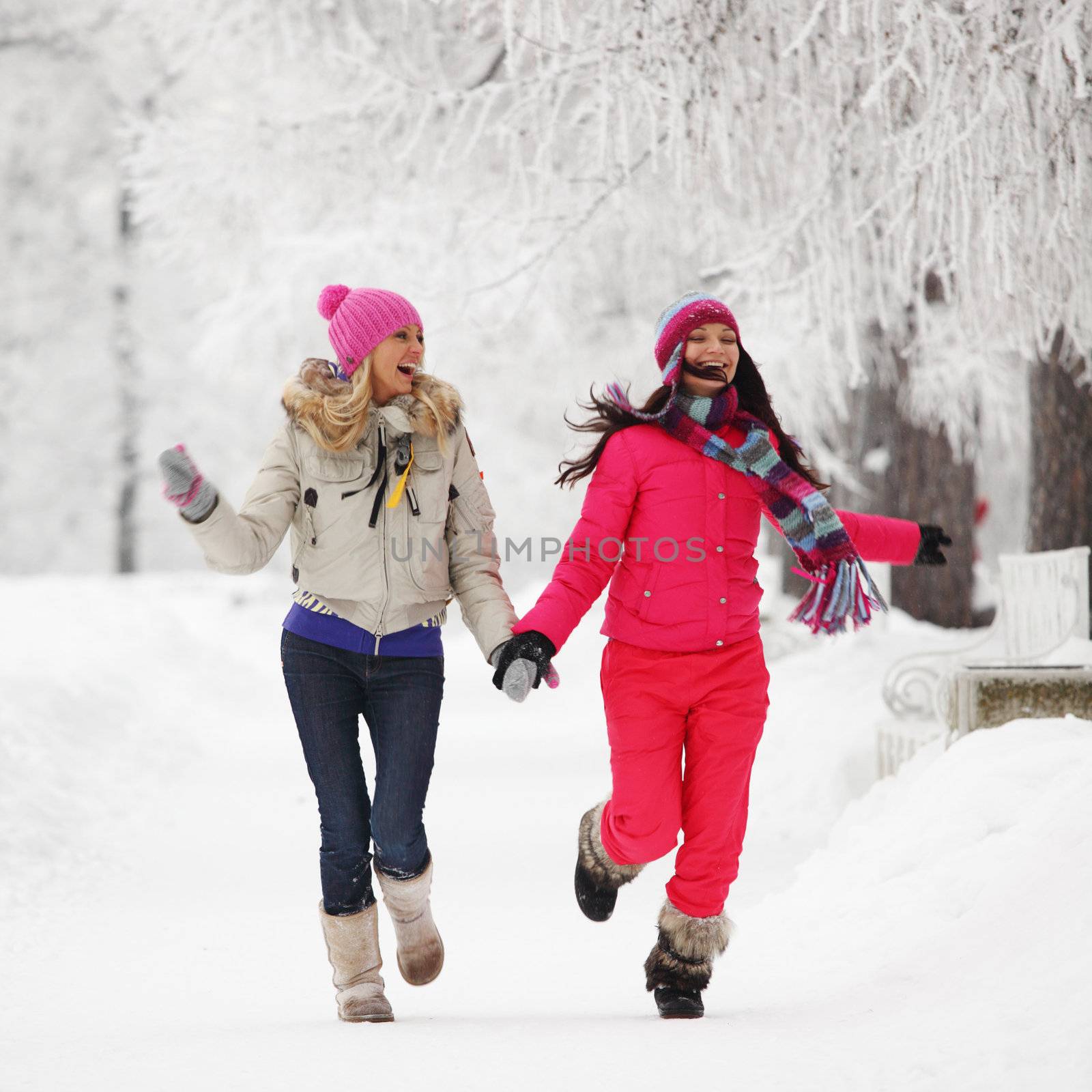 two winter women run by snow frosted alley