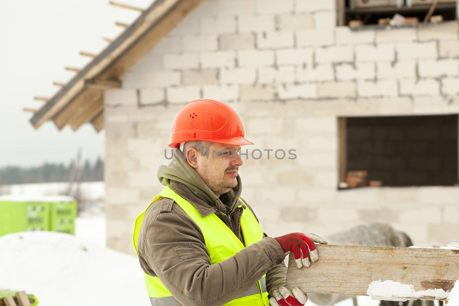 Builder with board at the hands near the construction works