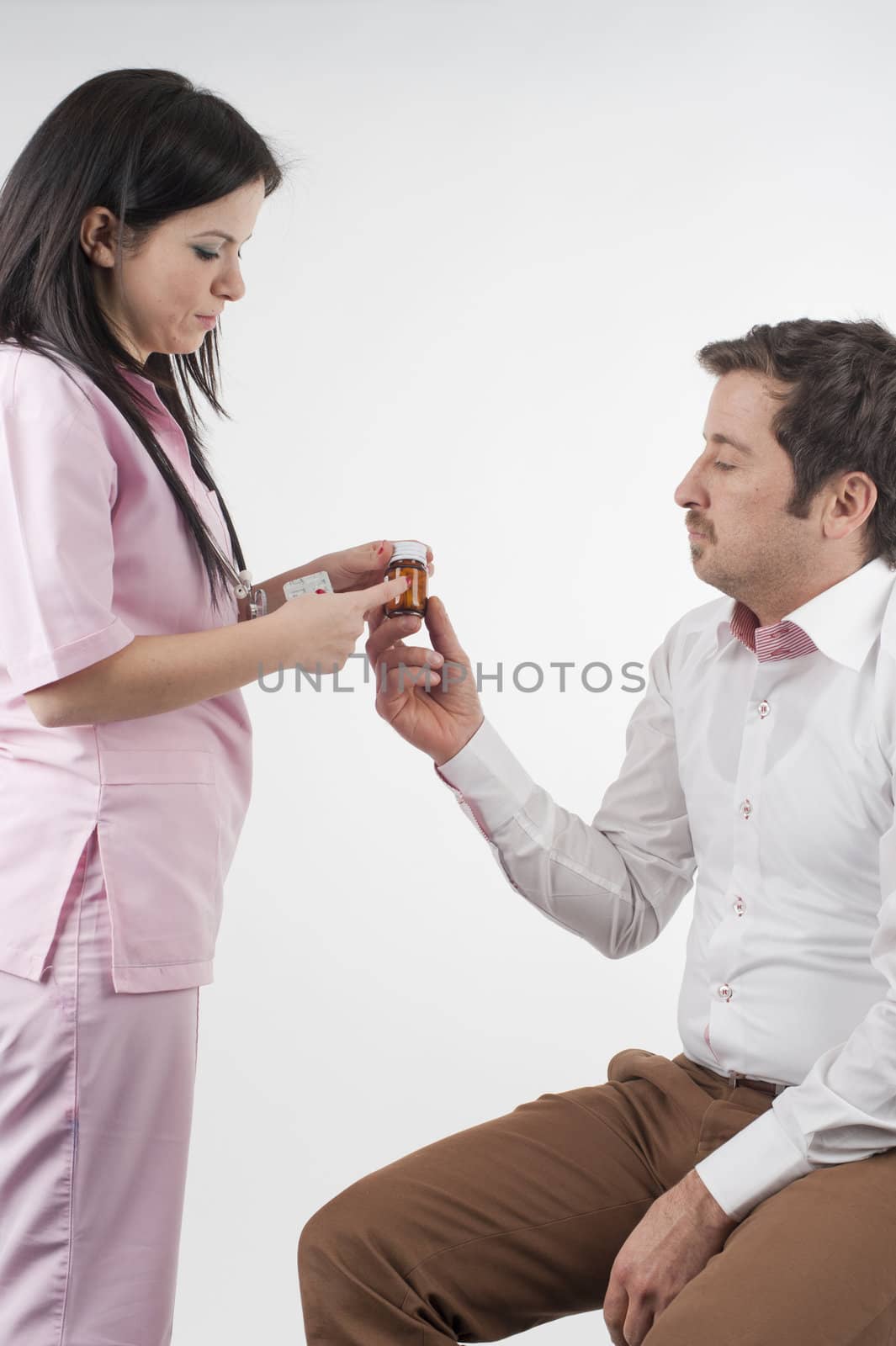 Nurse give pills to patient