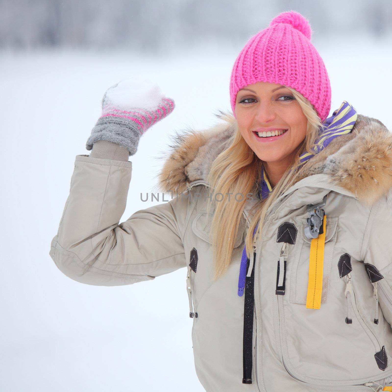 winter woman play snowballs on snow background