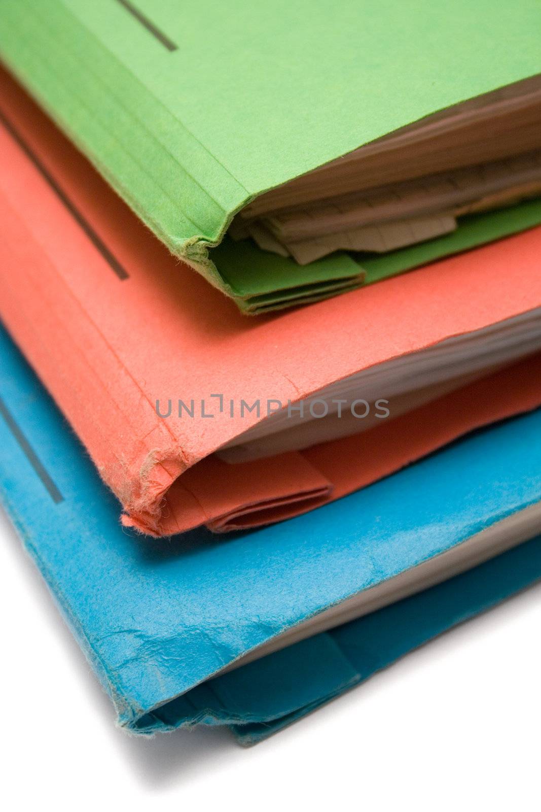 Stack of colorful binders full of documents.