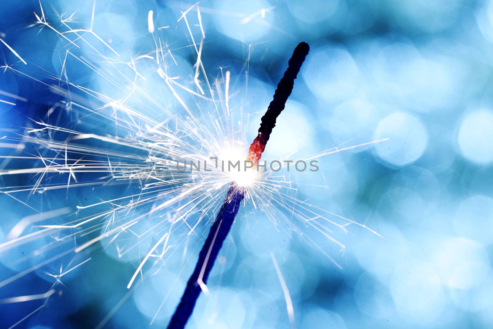 sparkler on blue bokeh background macro close up