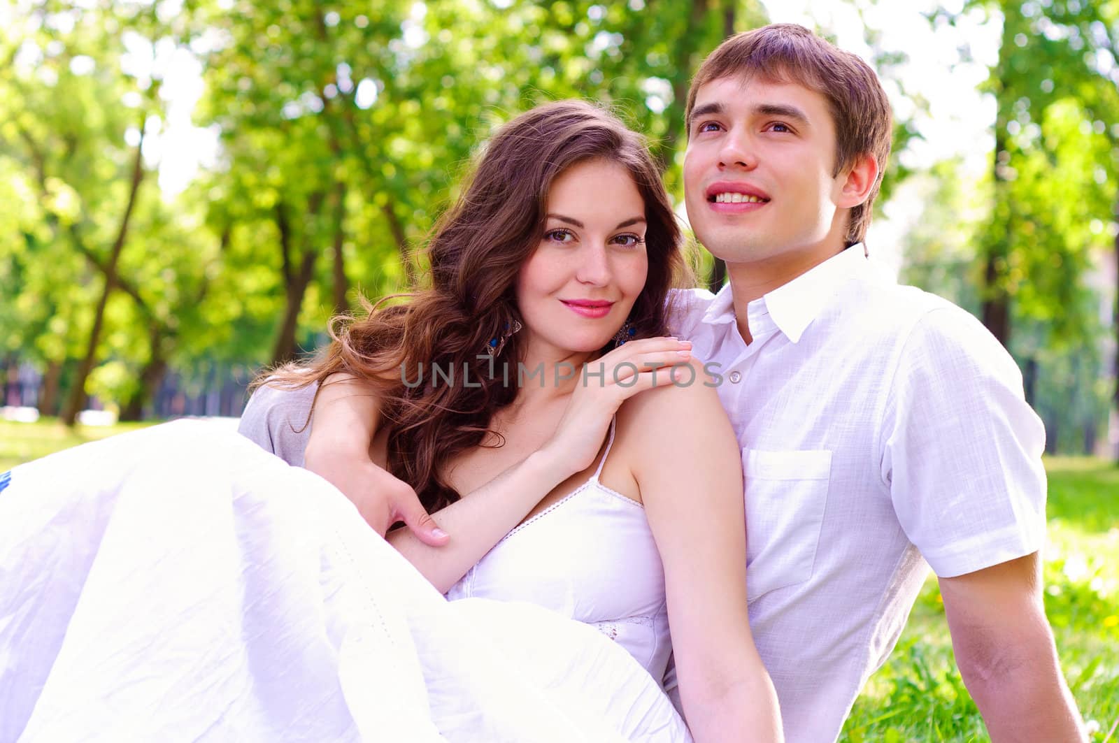 couple in the park sitting on the grass, have a good time together