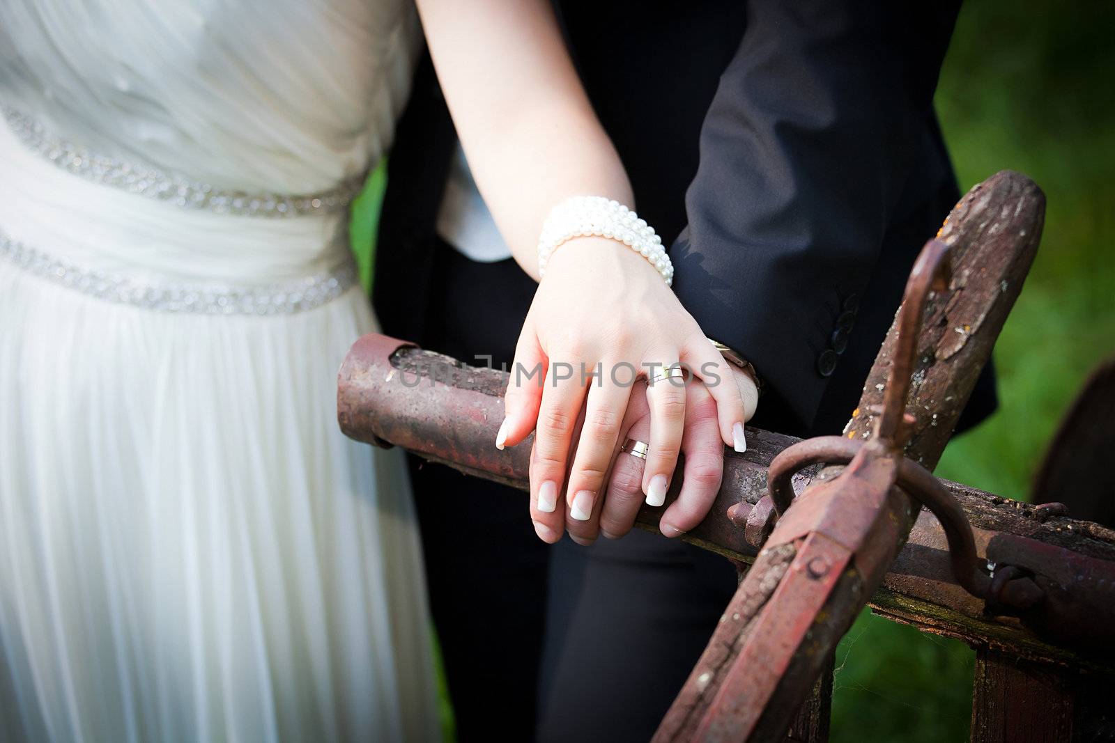Bride and groom holding hands and showing the engagement ring