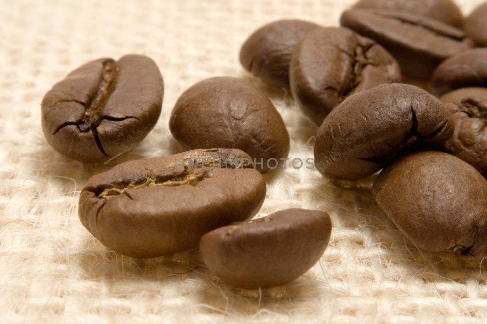Close-up on coffee beans on beige linen.