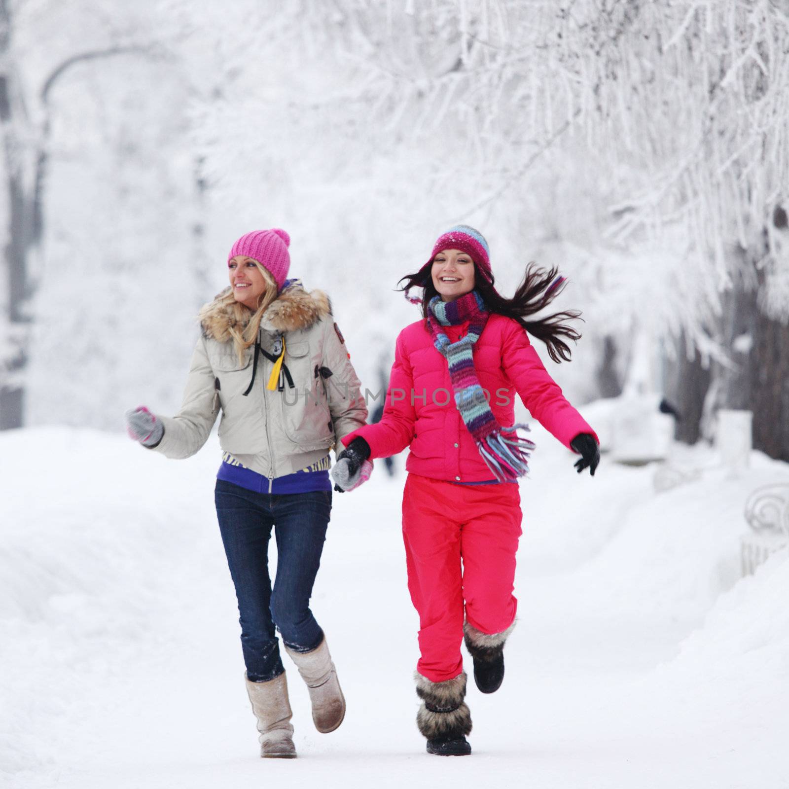 two winter women run by snow frosted alley