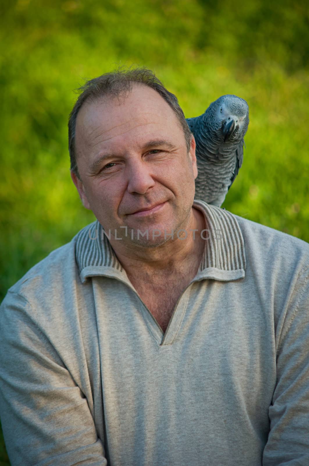 Portrait of  man with a gray parrot Jaco.
