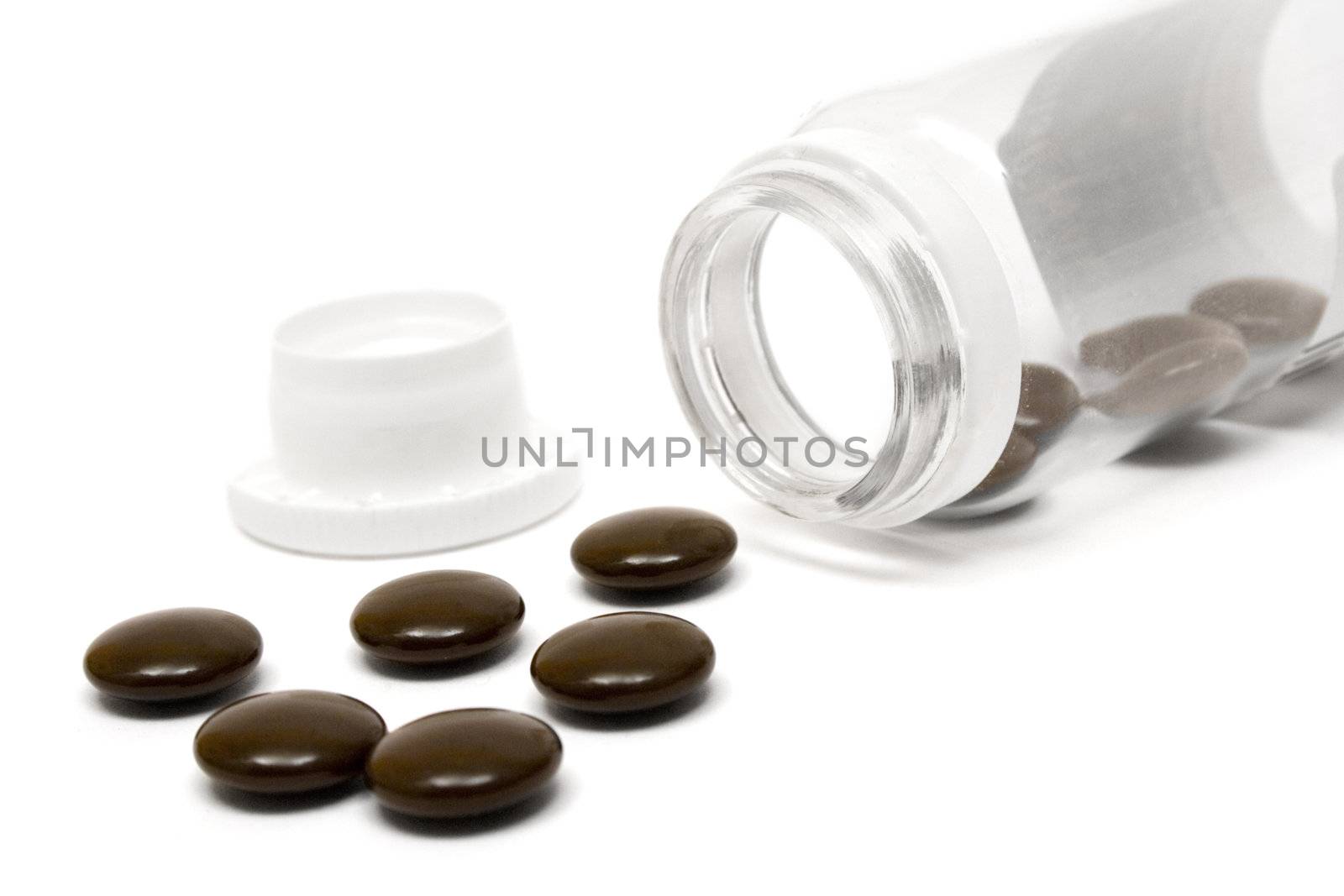 Pill container with brown pills. Isolated on a white background.