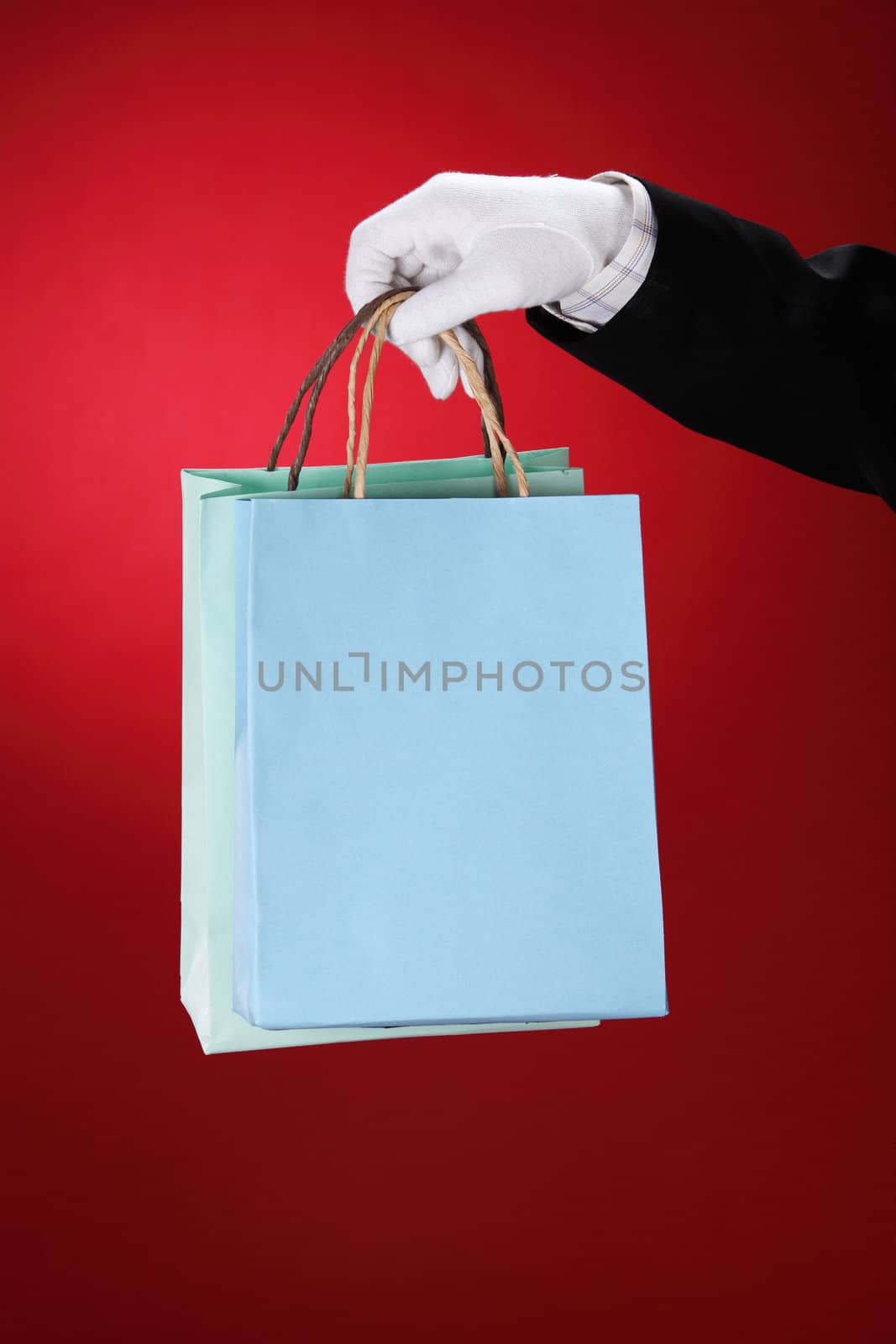 Doorman wearing white gloves, holding shopping bags