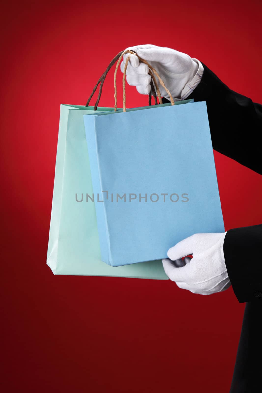 Doorman wearing white gloves, holding shopping bags