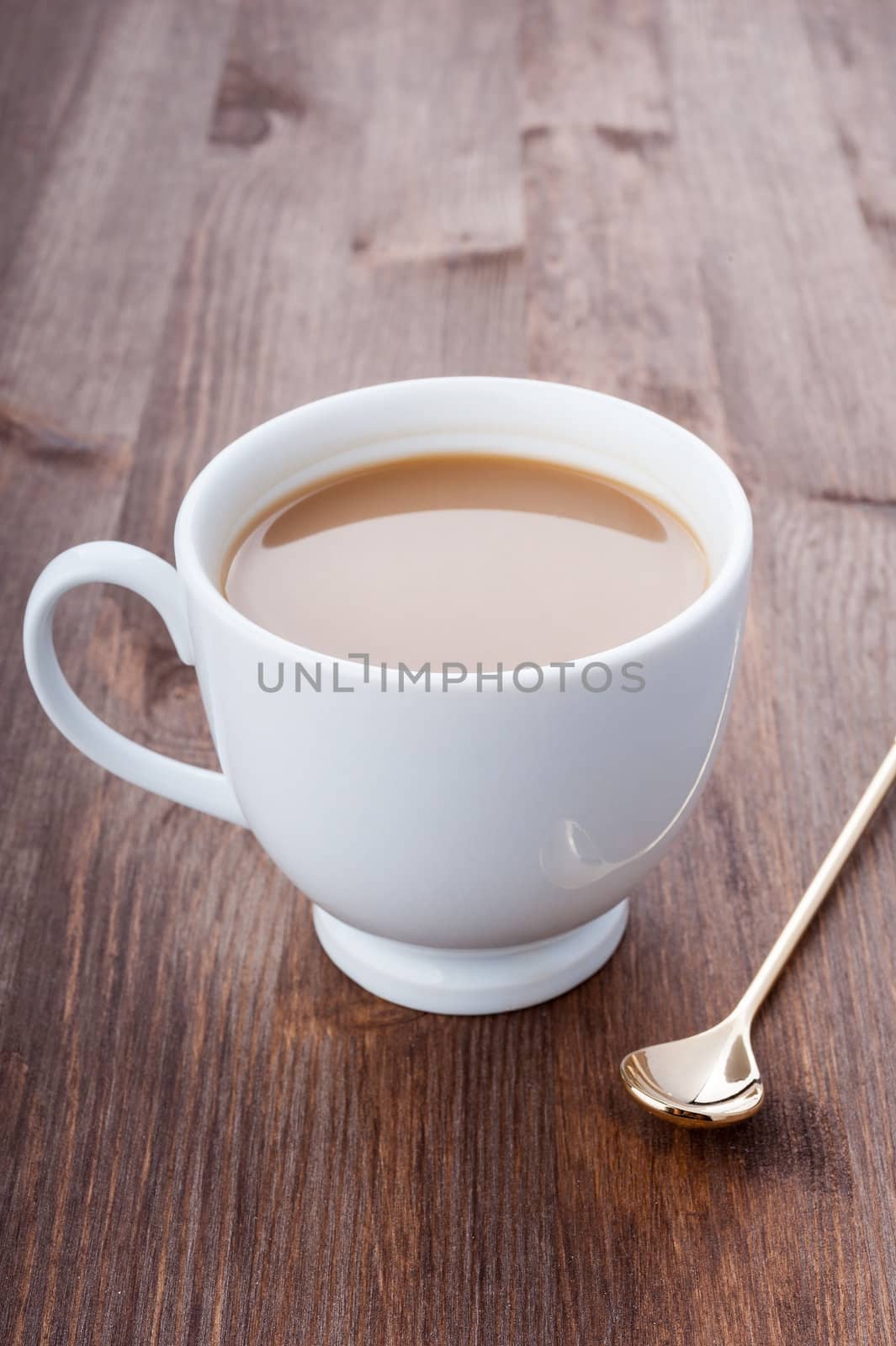 White cup of coffee with milk on a dark wooden surface