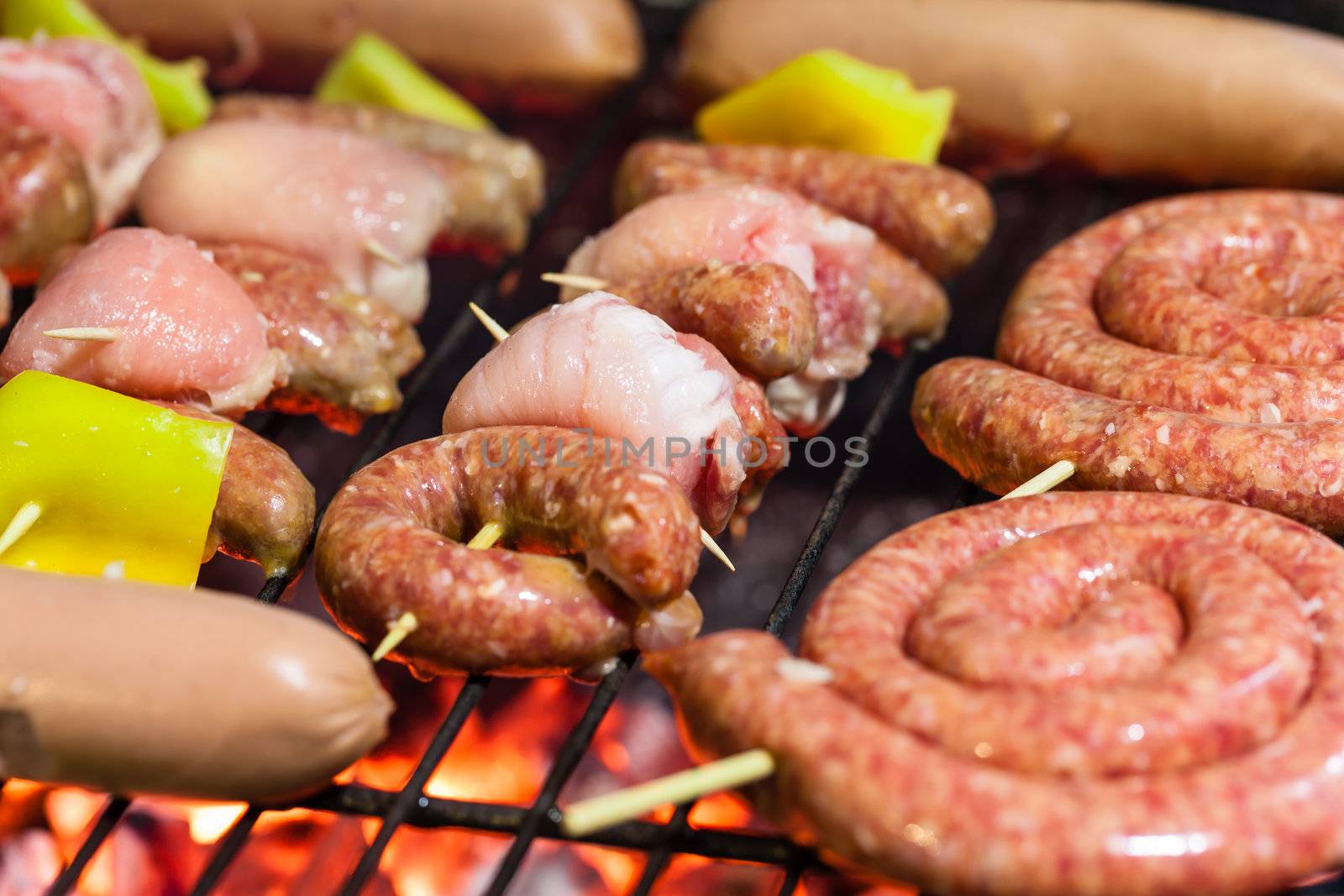 different types of meat cooking outside on a barbecue