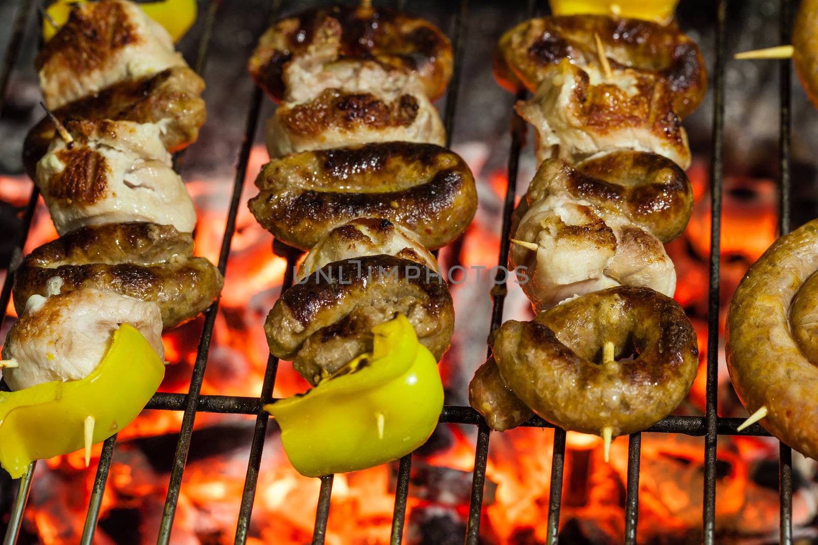 different types of meat cooking outside on a barbecue