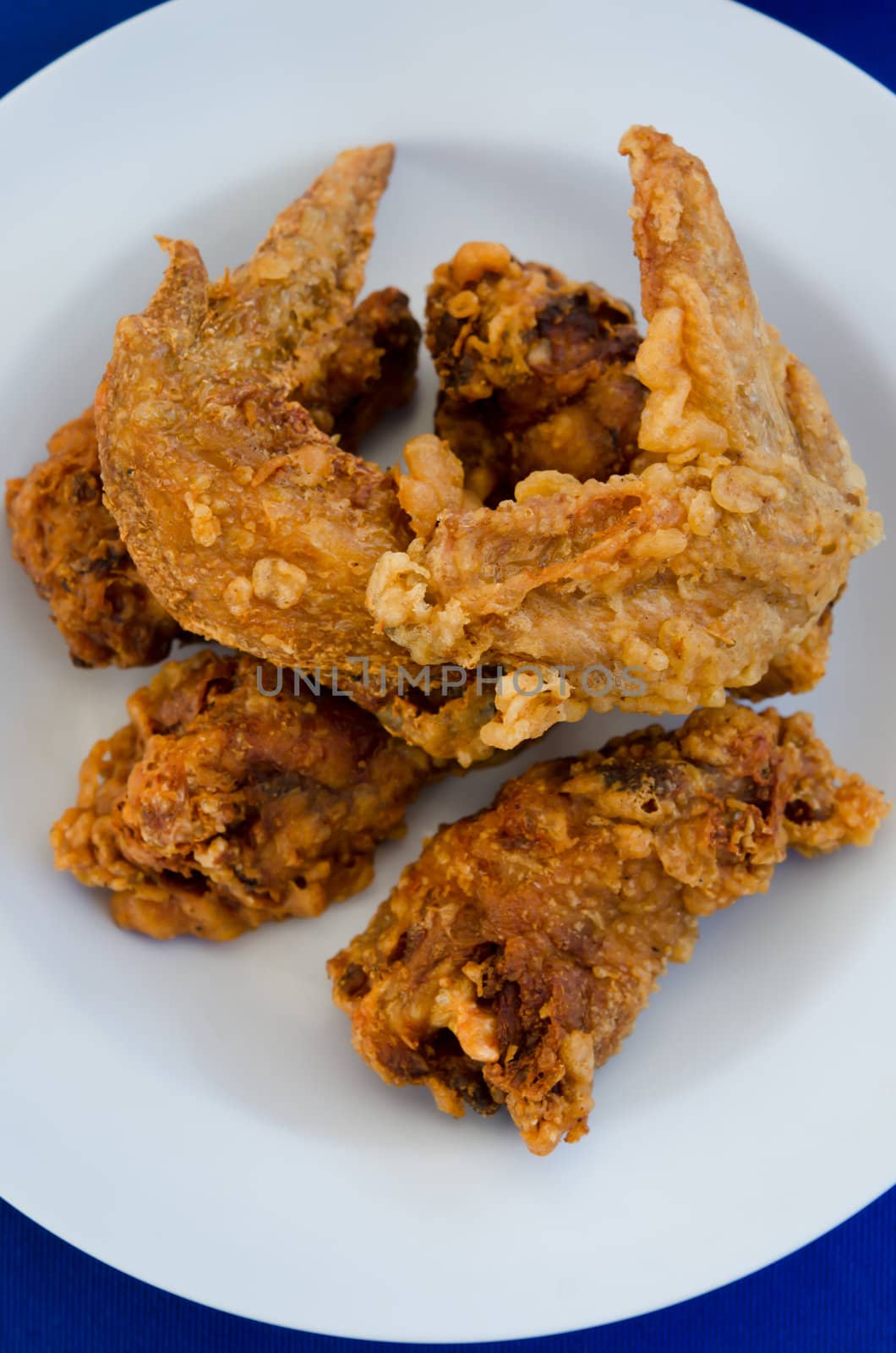 top view deep fried  chicken  on  dish , blue background