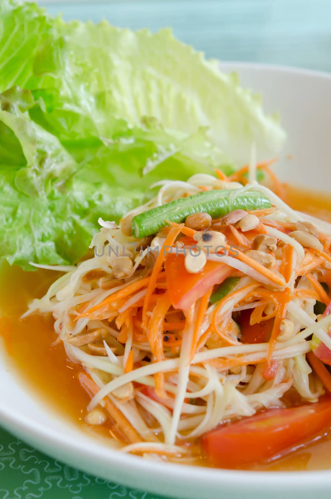  papaya salad and fresh lettuce on white plate