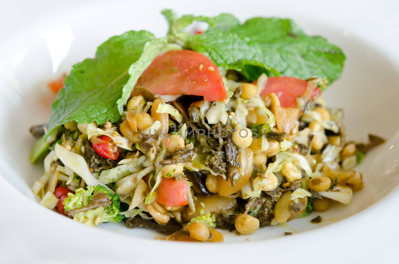 Tea Leaf Salad (Pickled green tea leaves, cherry tomatoes, cabbage, fresh lime, fried garlic, sesames seed, and roasted nuts)