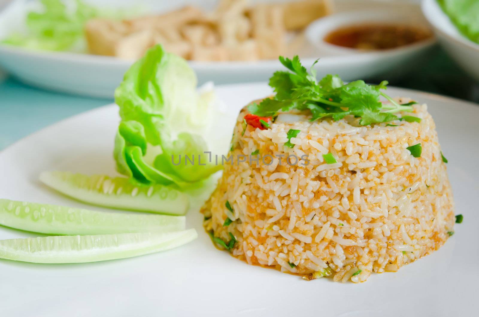 fried rice served with fresh vegetable on white plate