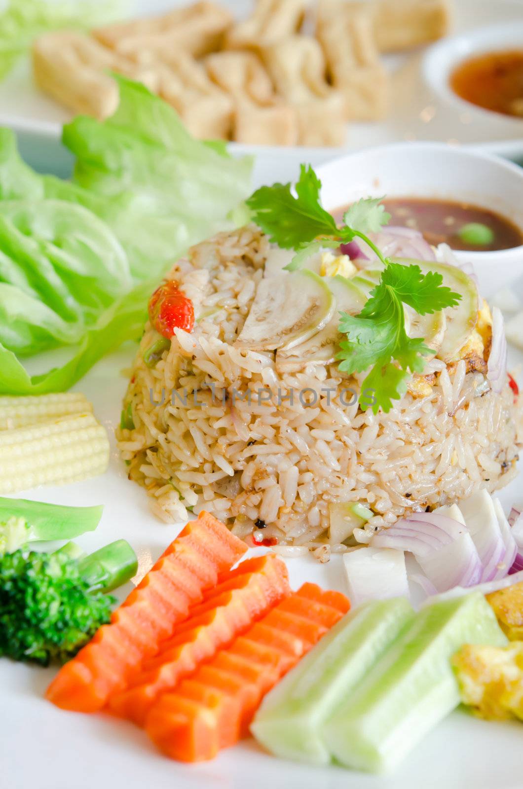 asian food , mixed cooked rice with shrimp paste sauce , fried egg and fresh vegetable.