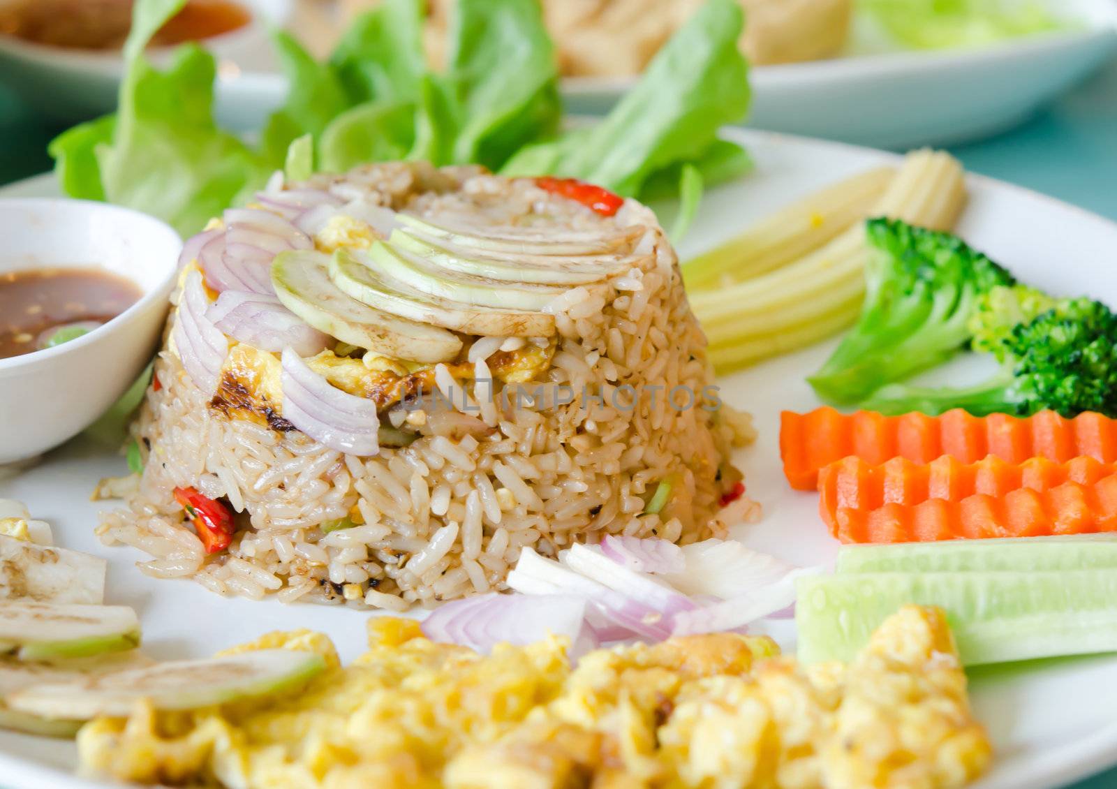 mixed cooked rice with shrimp paste sauce , fried egg and fresh vegetable. sweet and spicy