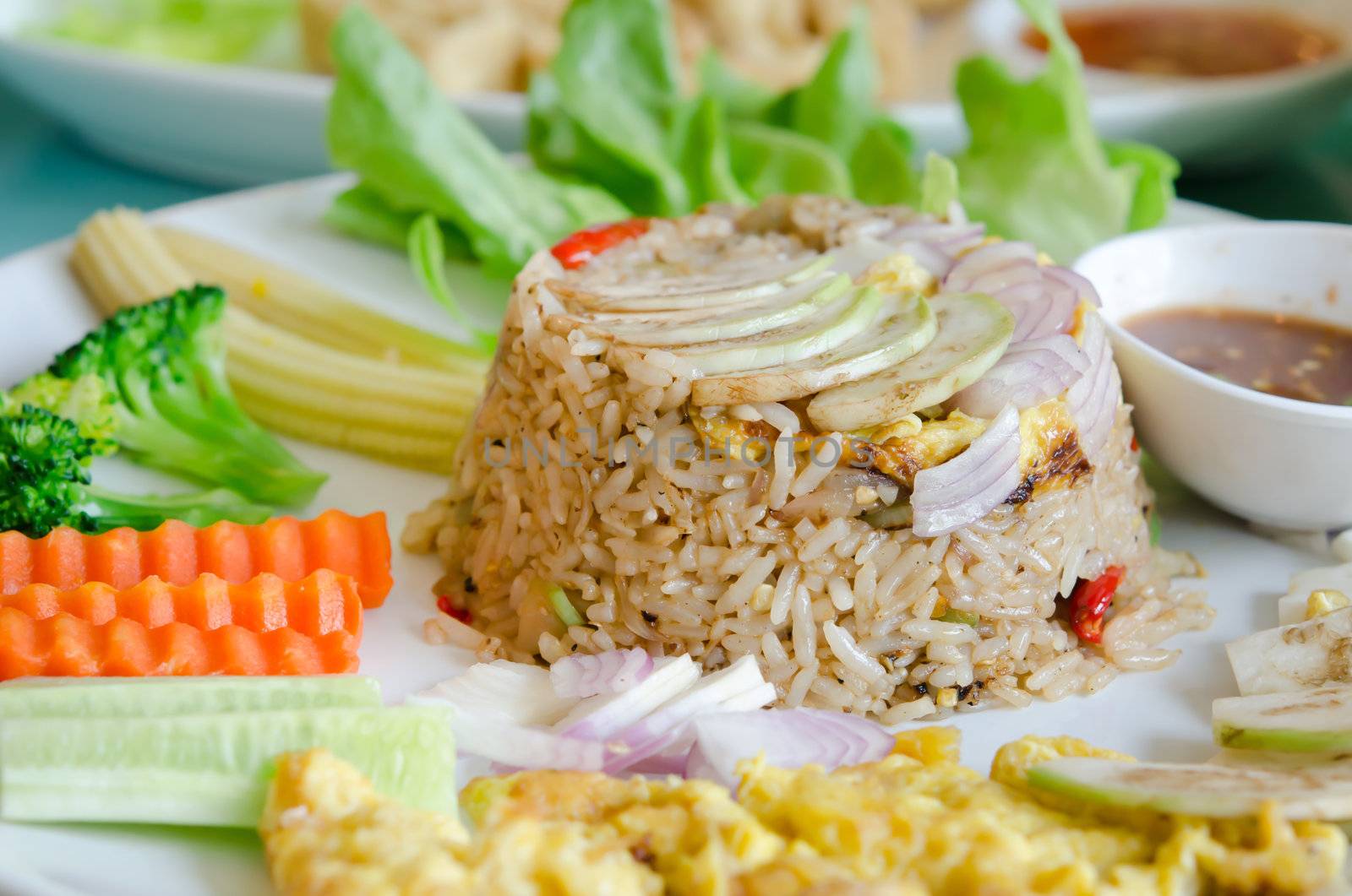 mixed cooked rice with shrimp paste sauce , fried egg , fresh vegetable and chili sauce
