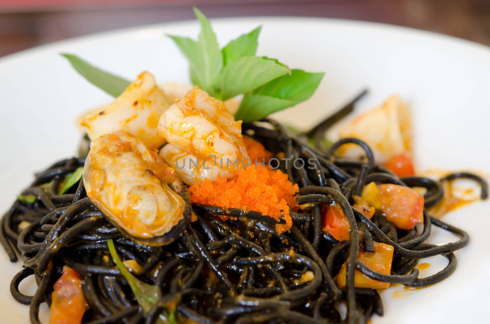 Black spaghetti with green mussel , fish eggs and shrimp  on white dish