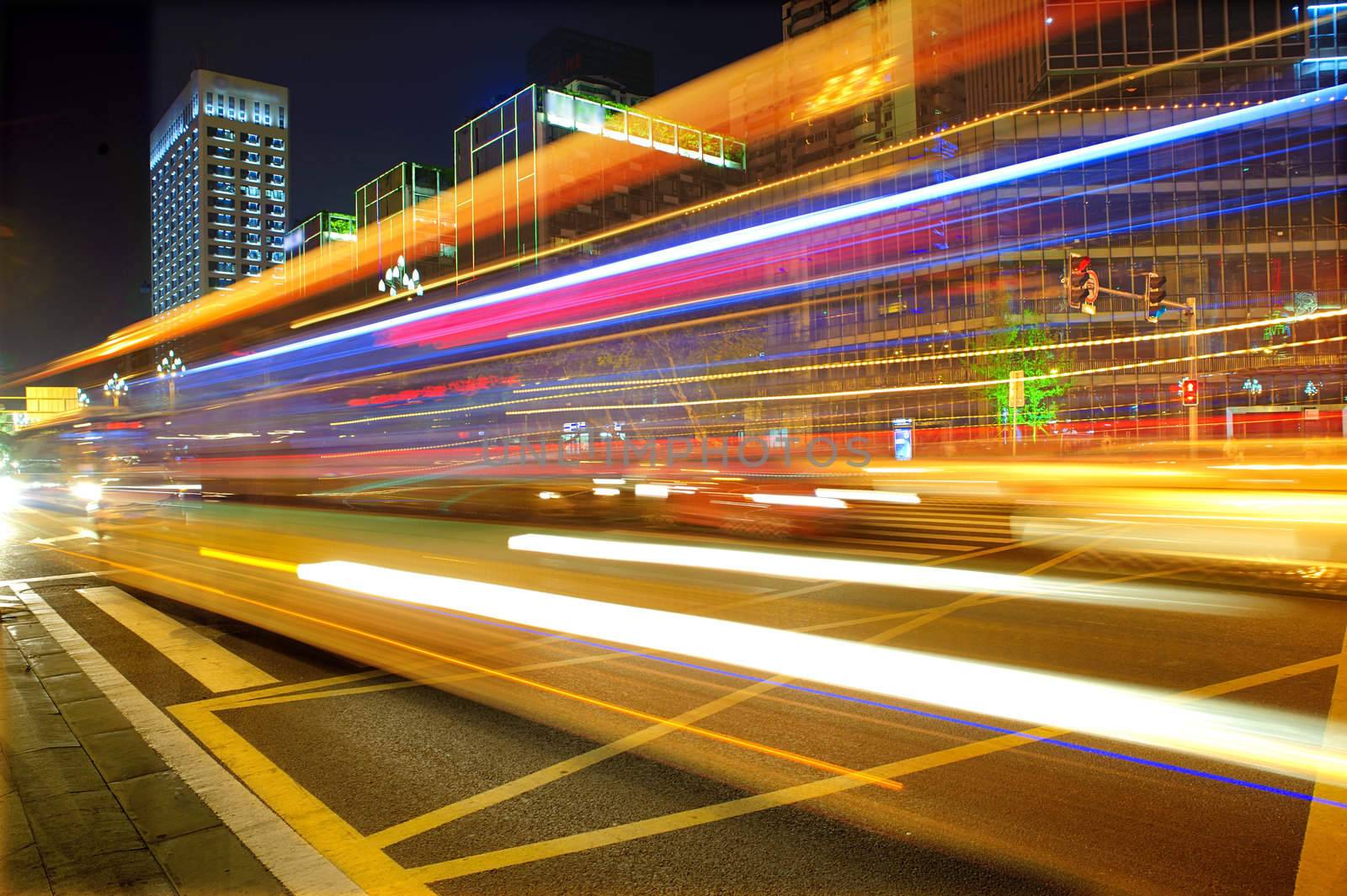 High speed and blurred bus light trails in downtown nightscape by jackq