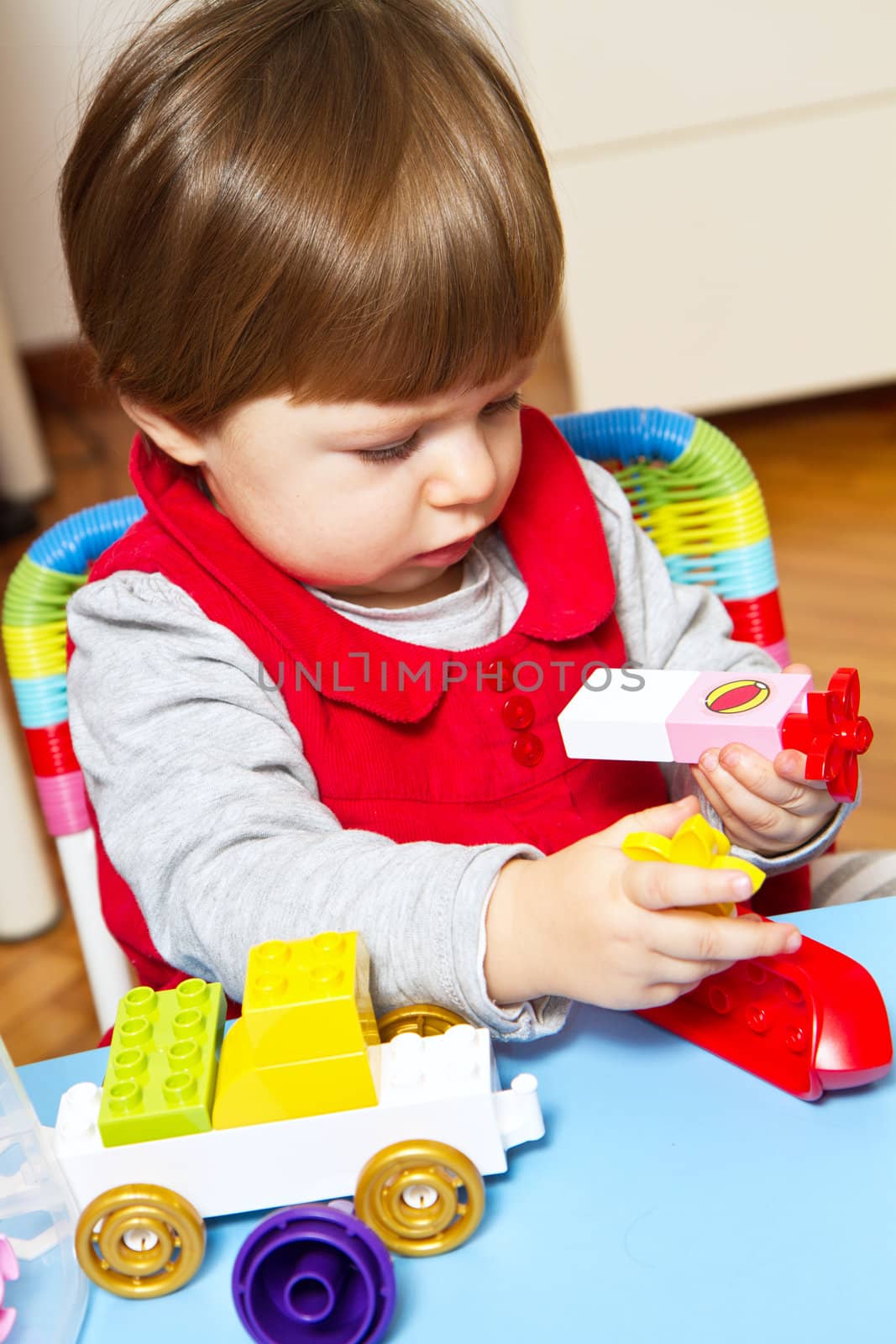 baby girl is playing with building bricks