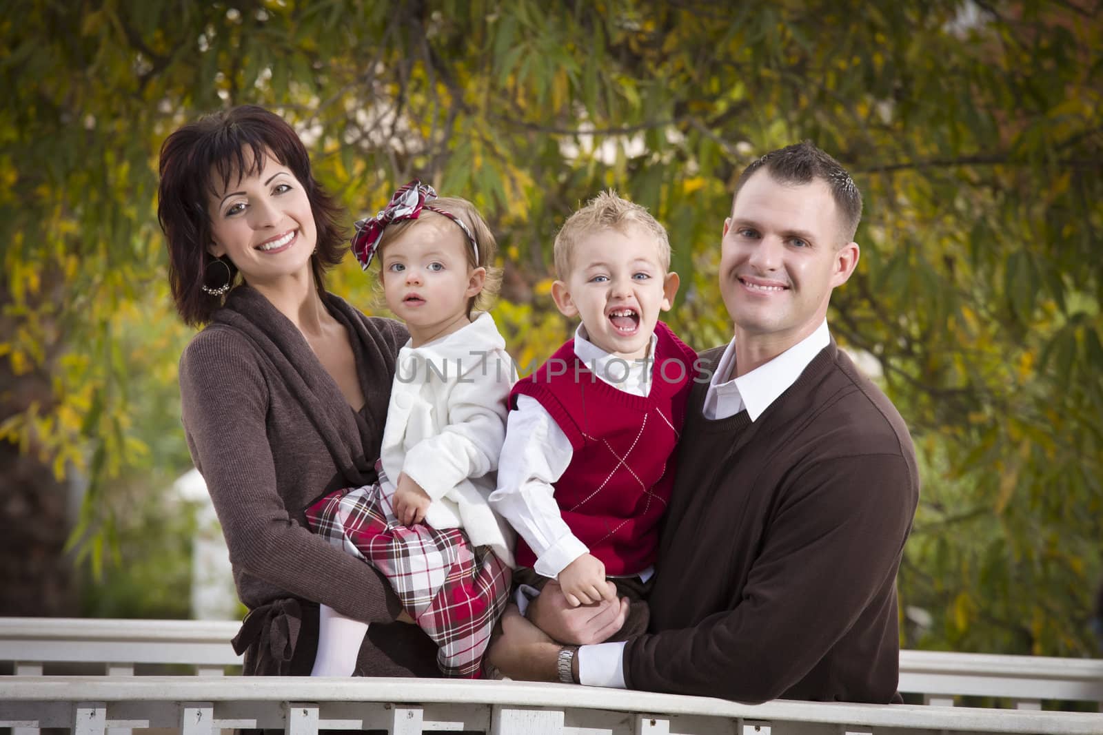 Young Attractive Parents and Children Portrait Outside in the Park.