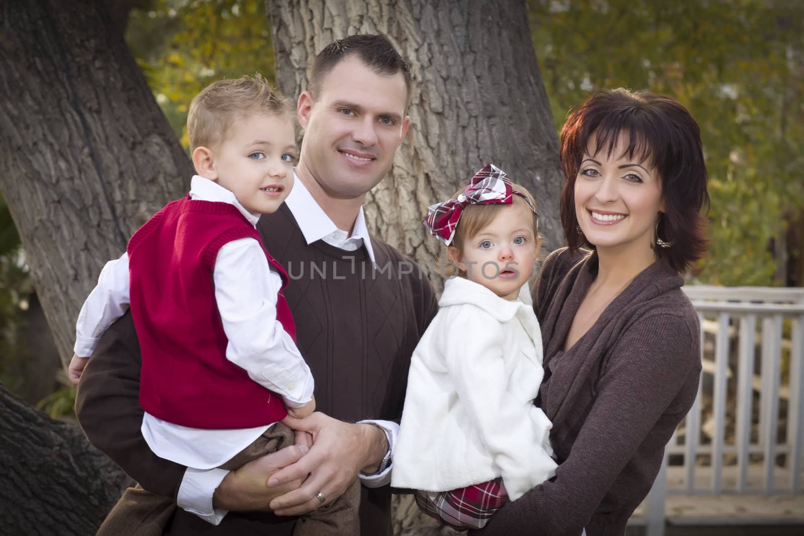 Young Attractive Parents and Children Portrait Outside in the Park.