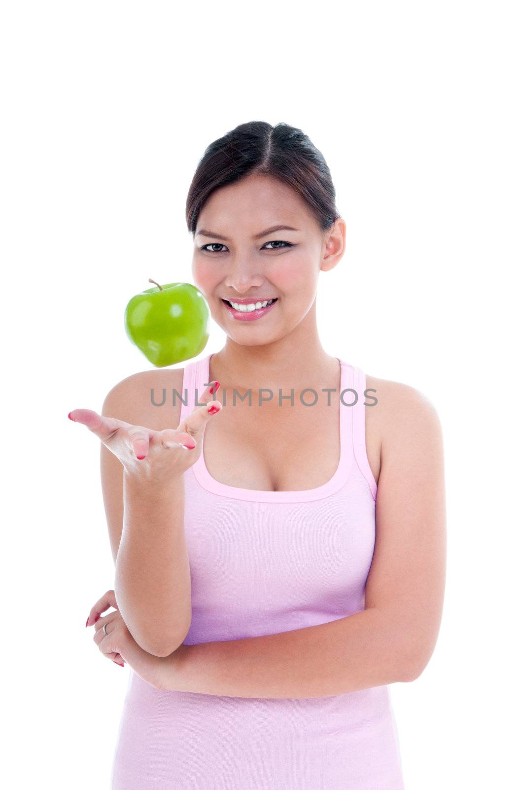 Portrait of a young healthy woman playing with green apple over white background.