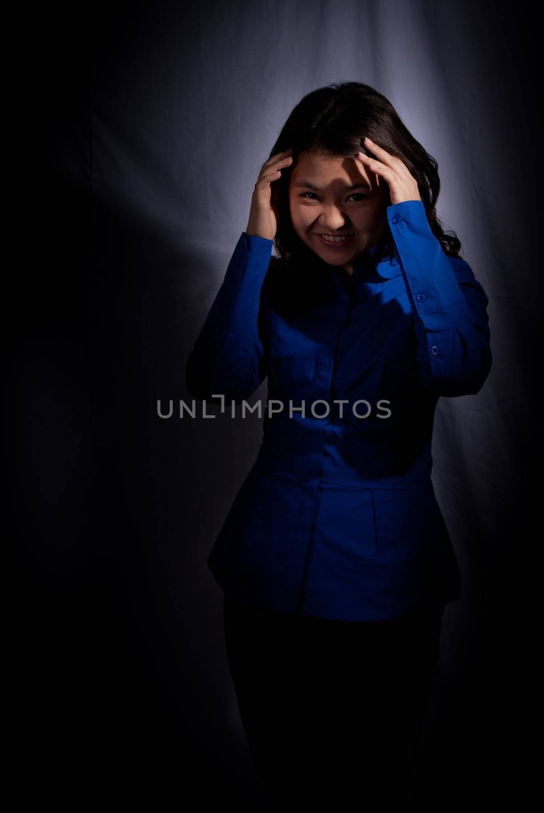 Asian girl in spotlight on black background