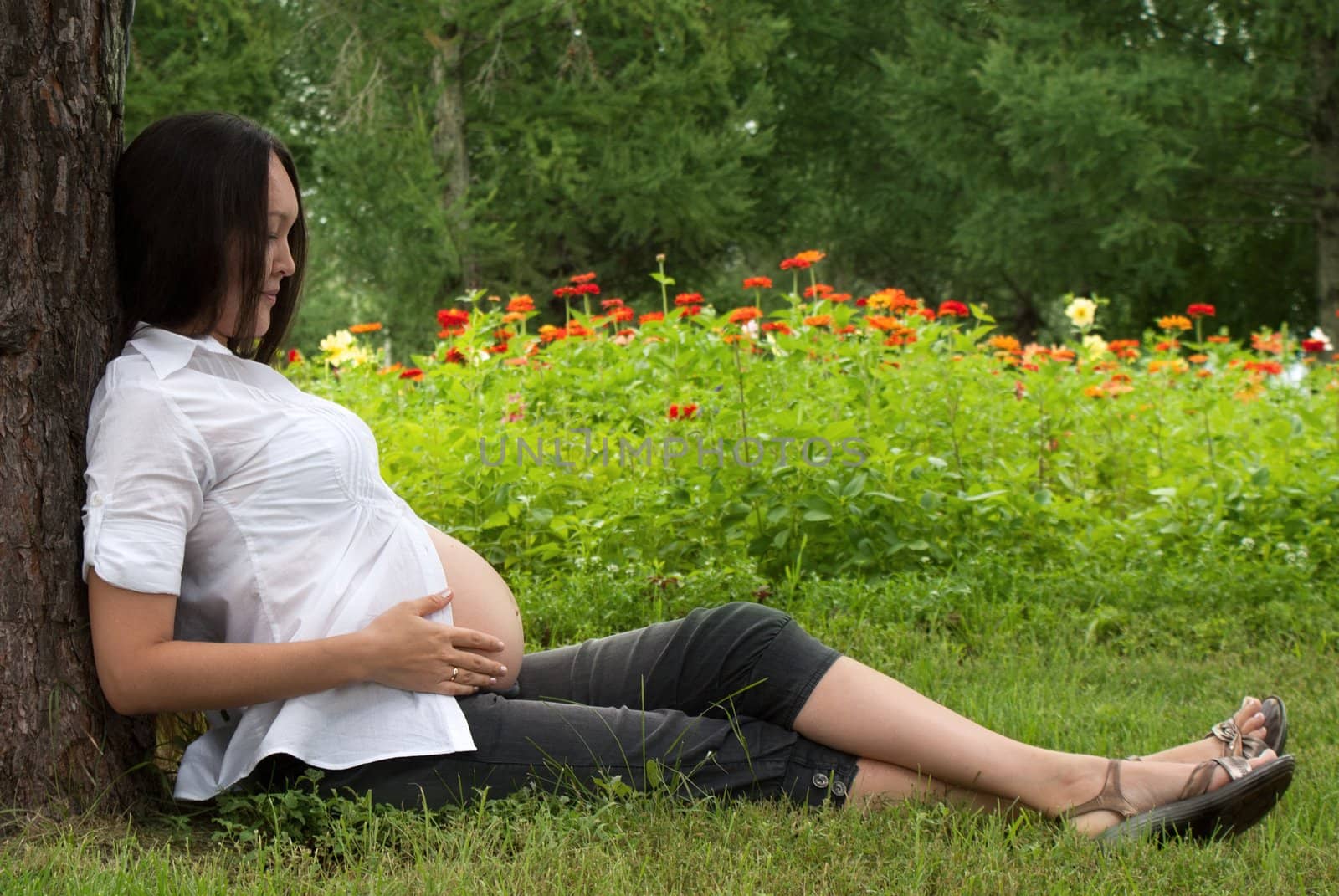 Beautiful pregnant asian woman relaxing in the park.