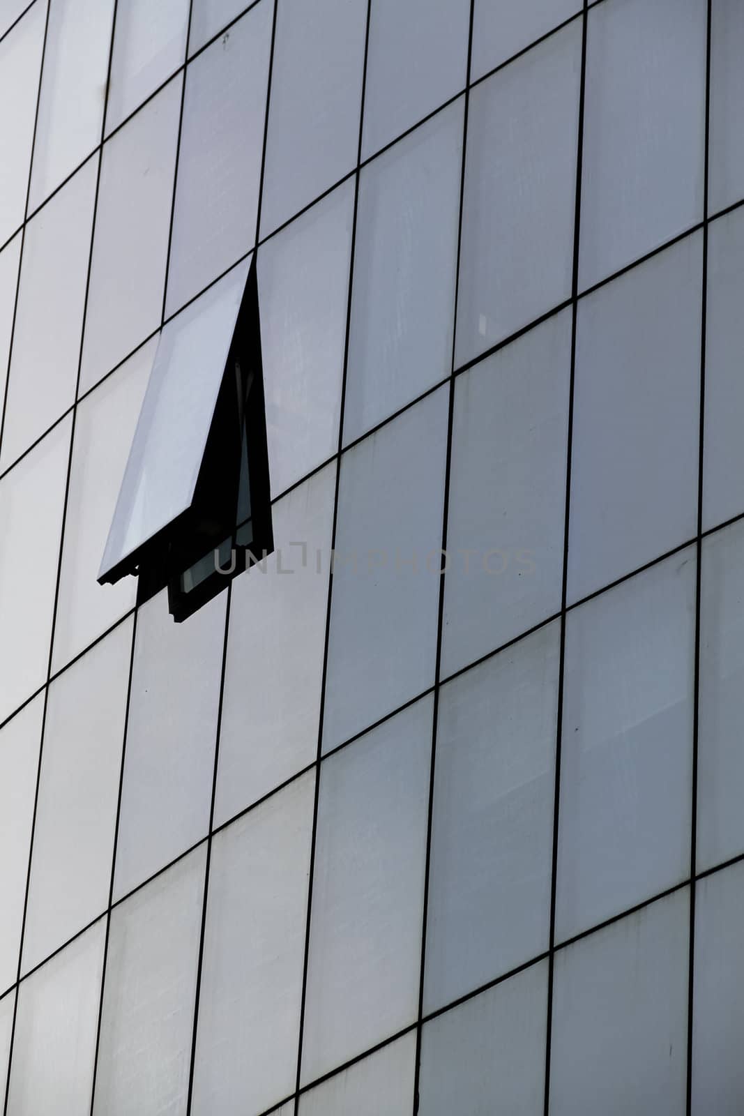 A glass front of a skyscraper with an open tile in Vienna, Austria