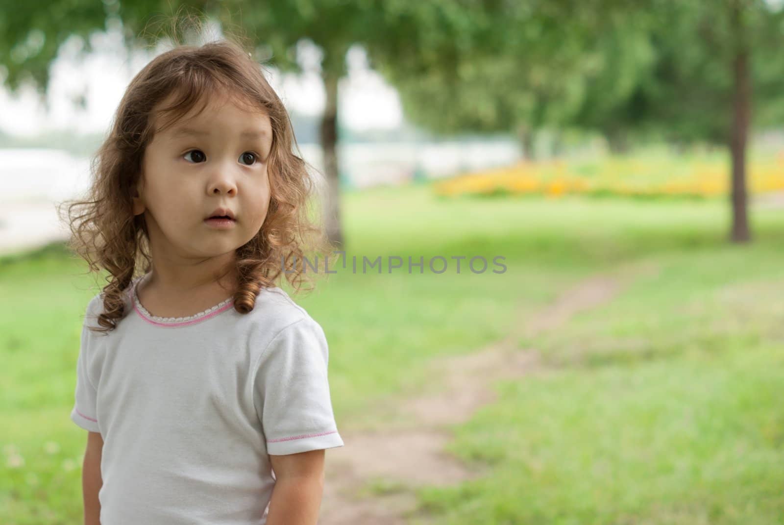 Cute asian baby outdoors at green background, portrait