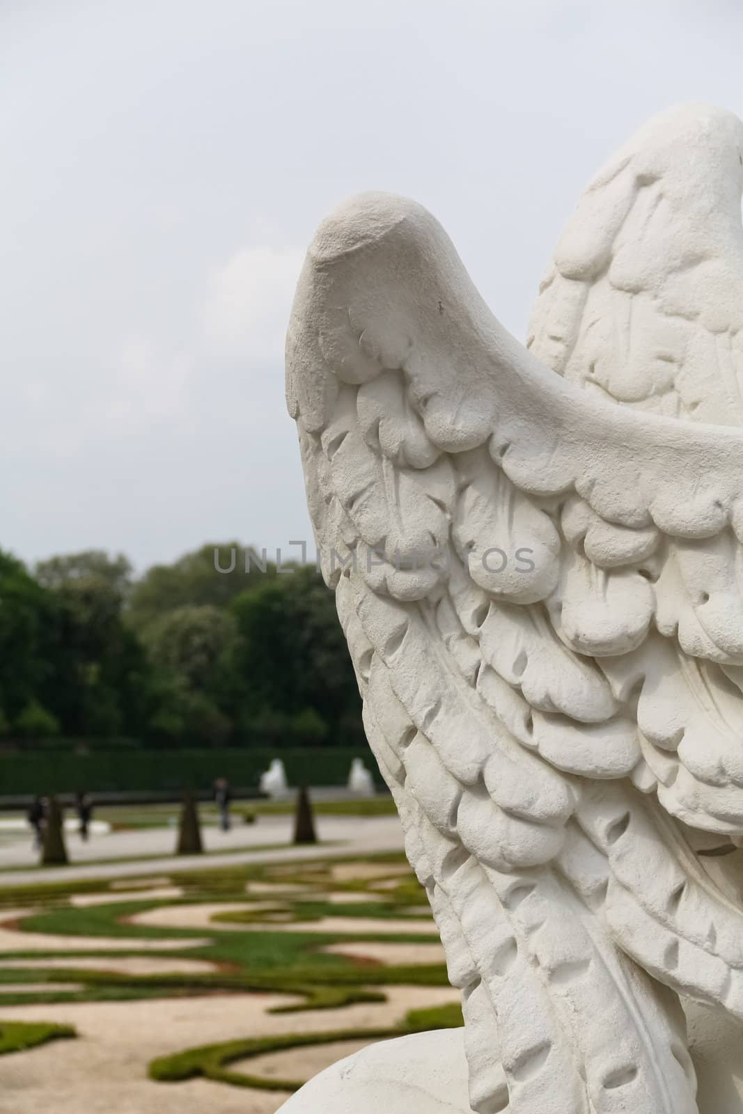 Castle Belvedere's park behind a statue's wings in Vienna, Austria