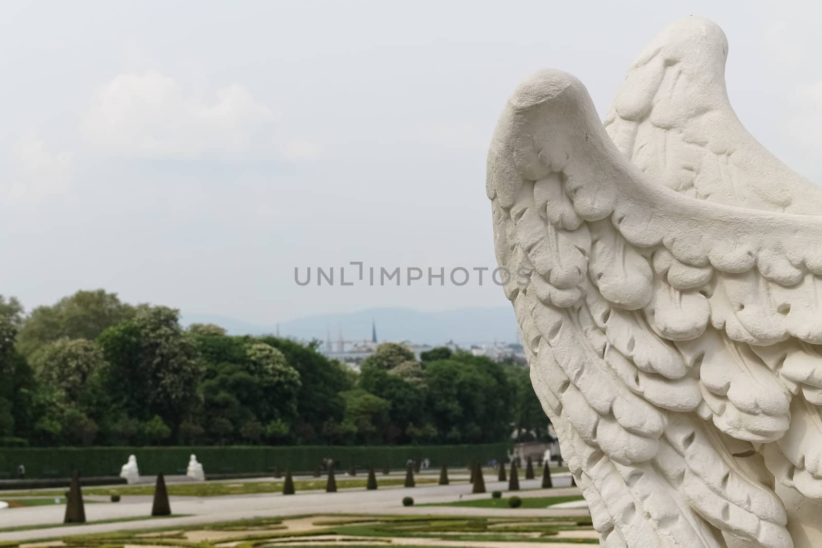 Castle Belvedere's park behind a statue's wings in Vienna, Austria